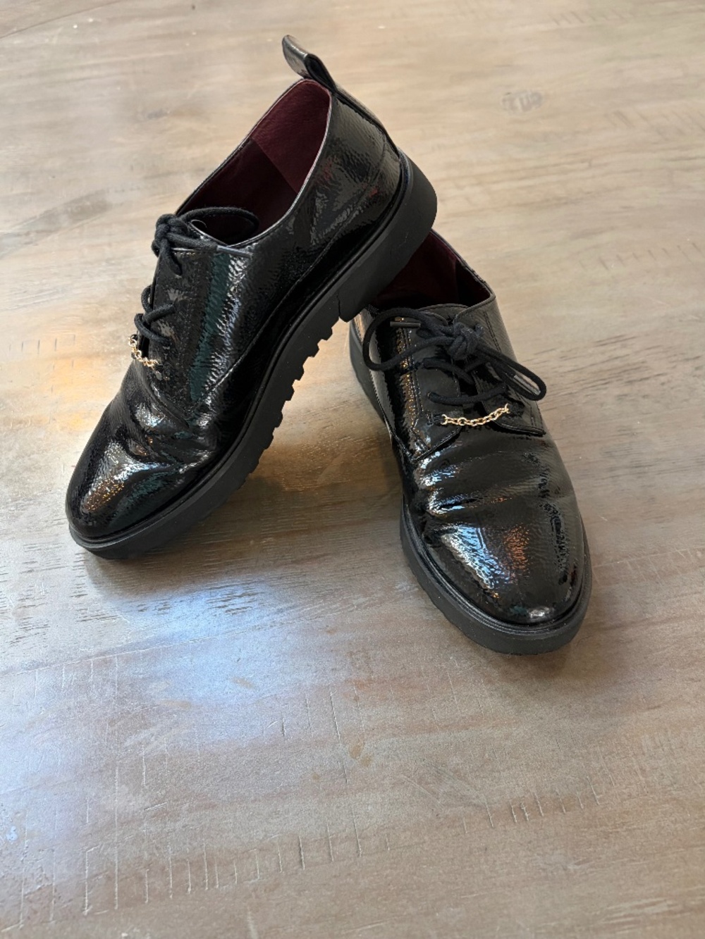 Franco Sarto black, patten Oxfords with gold chain accent.